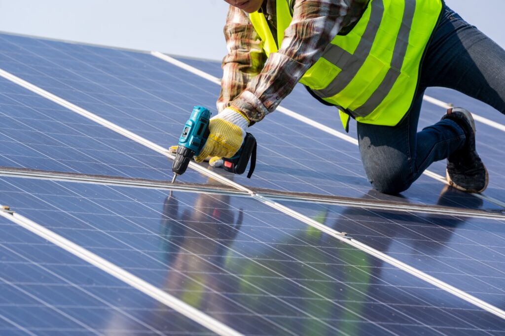 Photovoltaic,Male engineer installing solar photovoltaic panel system using screwdriver.