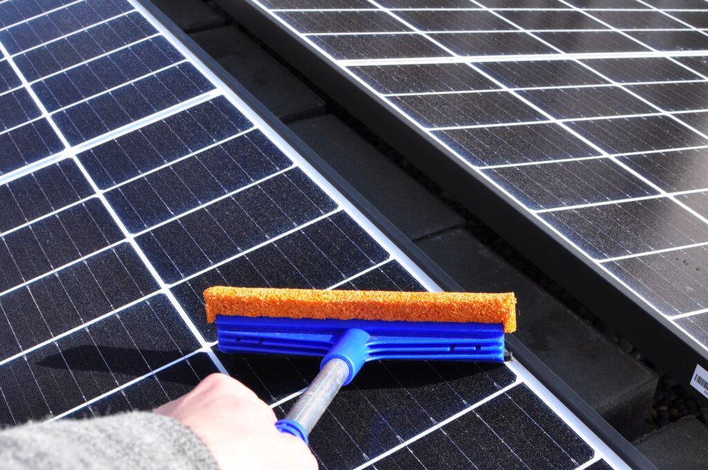 Cleaning solar panels with a wiper